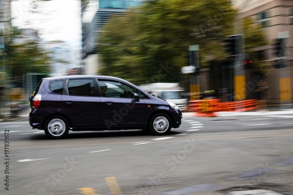Fototapeta Car in motion on the road, Sydney, Australia. Car moving on the road, blurred buildings in background.