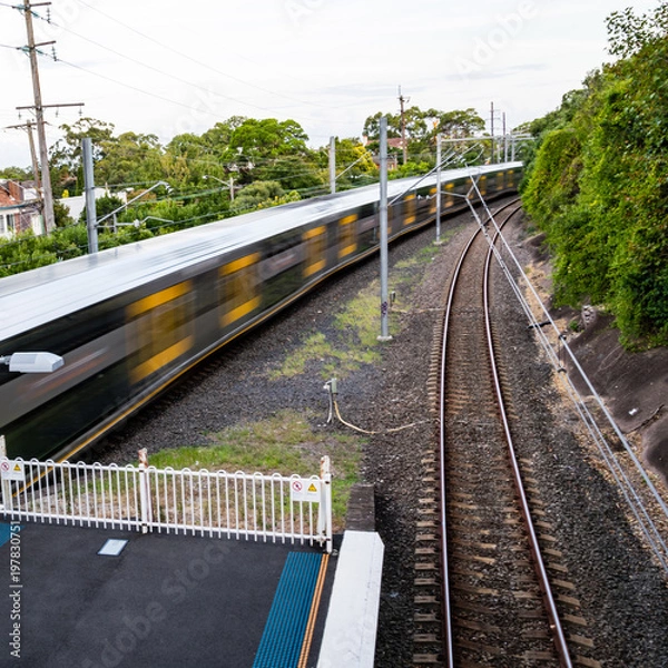 Obraz The platform of train station with train in motion, Sydney, Australia. Blurred motion of a train, shooting from a high angle.