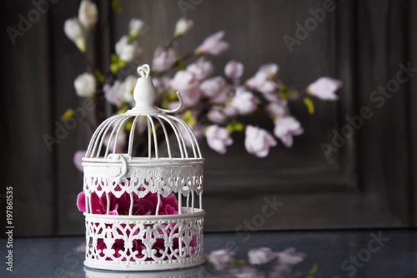 Obraz white cage with flower inside on the table