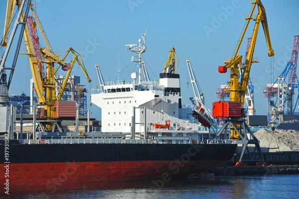 Fototapeta Bulk cargo ship under port crane