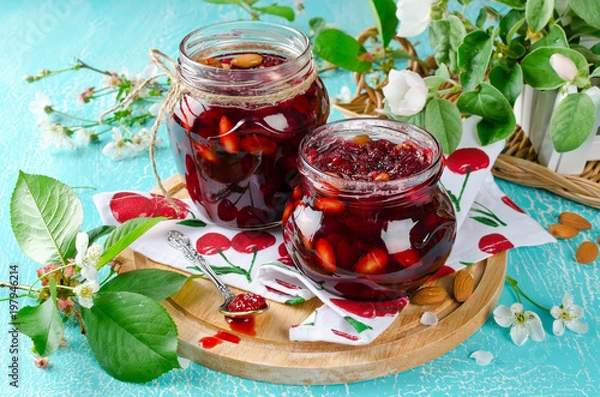 Fototapeta Cherry jam with apple and almonds on a blue background