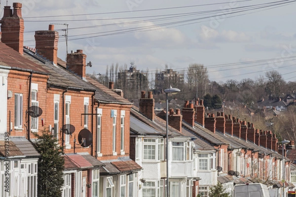 Fototapeta Row of terraced house roofs with chimney stacks