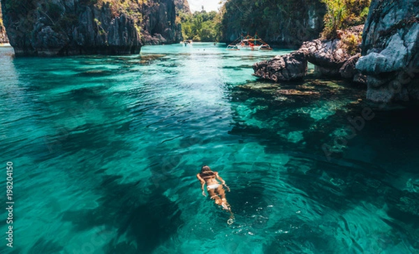 Fototapeta Woman swimming in clear sea water in Asia