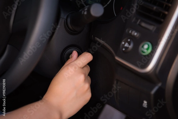 Fototapeta Close-up portrat of woman hand inserting key to turn on/off car engine
