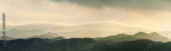 Fototapeta Niesamowity zachód słońca i niskie chmury nad wzgórzami Reserva Nacional La Chimba, widziane z La Portada