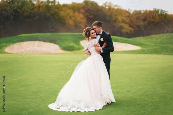 Obraz Beautiful bride and groom walking in Autumn Park