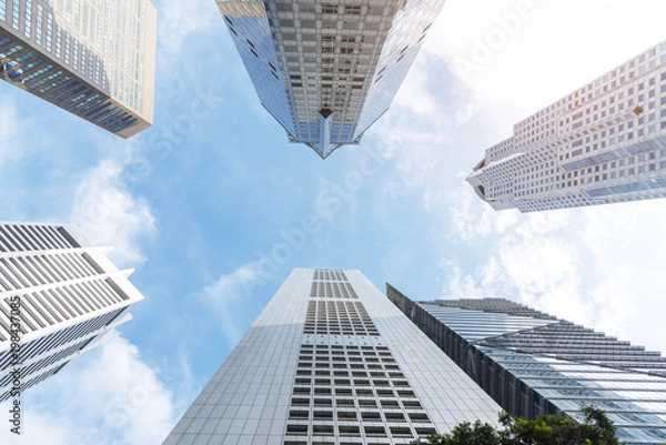 Fototapeta Exterior of modern high building in business city center with blue sky. Picture for add text message. Backdrop for design art work.
