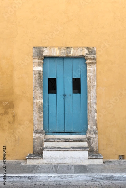 Fototapeta Yellow house with blue wooden door in San Francisco de Campeche, Mexico