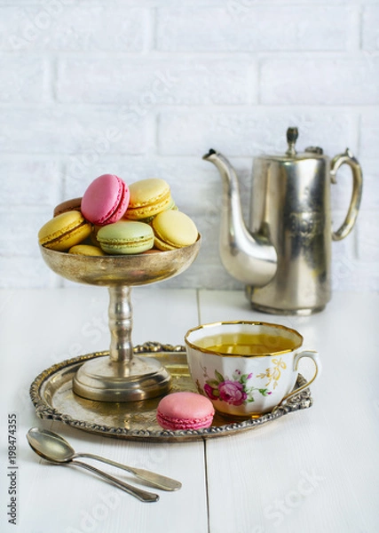 Fototapeta Multicolored macaroons in a metal vintage bowl on a white table