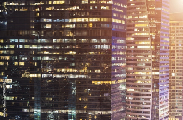 Fototapeta Abstract background from closeup of glasses window in modern building at night. business and finance background.