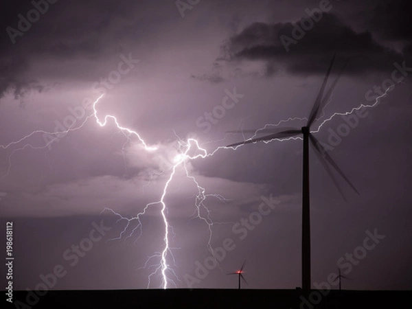 Obraz Thunderstorm with lightnings over a wind farm