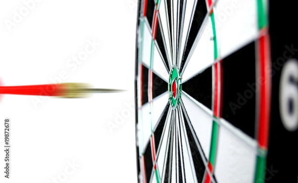 Obraz Dartboard with flight of dart on the bullseye
