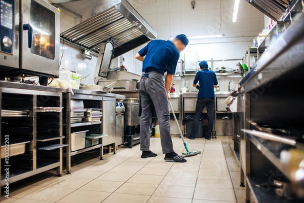 Obraz assistant cleans in the kitchen