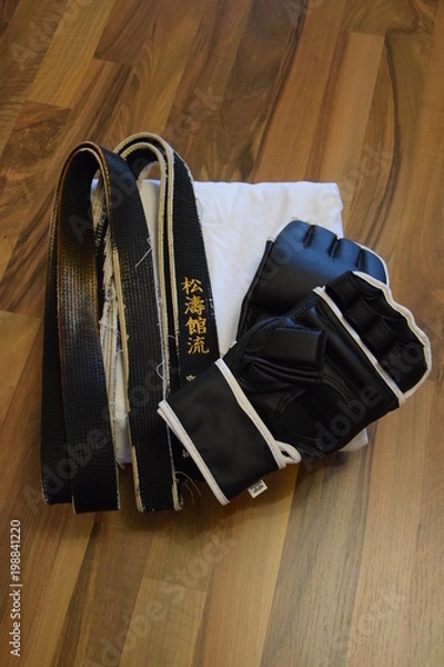 Fototapeta Karate-Anzug mit Schwarzgurt und Faustschutz