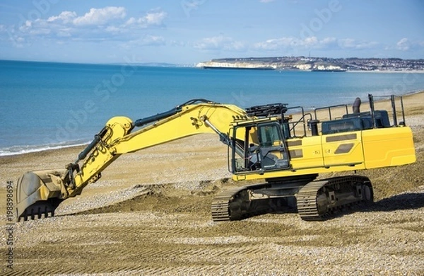 Obraz Construction - Heavy Machinery Construction Site - Engineering - Sea Defence. Large plant machinery being use to build the beach sea defence at Seaford, East Sussex, UK