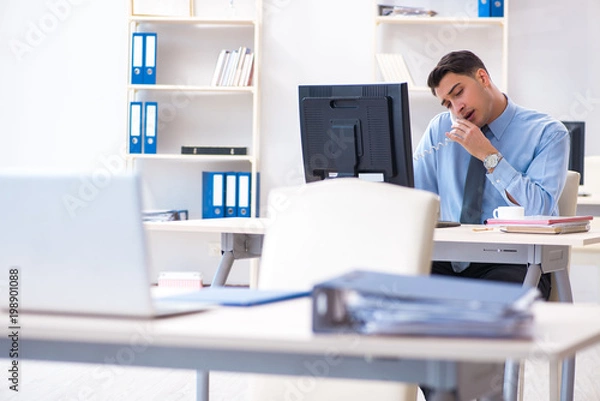 Fototapeta Handsome businessman employee sitting at his desk in office