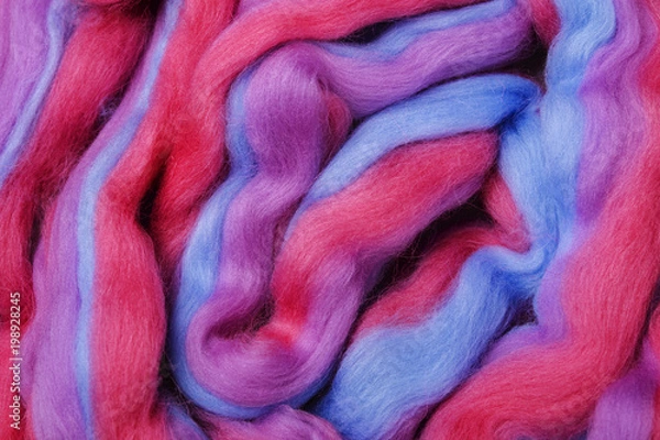 Fototapeta Bright colored merino wool for felting and needlework, hobby. The stripes of pink, blue and violet color yarn folded into abstract pattern. Abstract art background