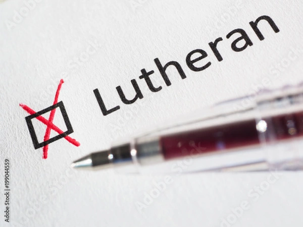 Fototapeta Questionnaire. Red pen and the inscription LUTHERAN with check mark on the white paper. Close-up background. High-quality macro photography.