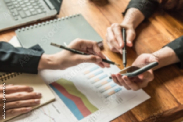 Fototapeta working woman are working at coffee shop they use mobile phone to search data about they's work from social network and  they have laptop , papers graph and note to help for work put on wooden table.