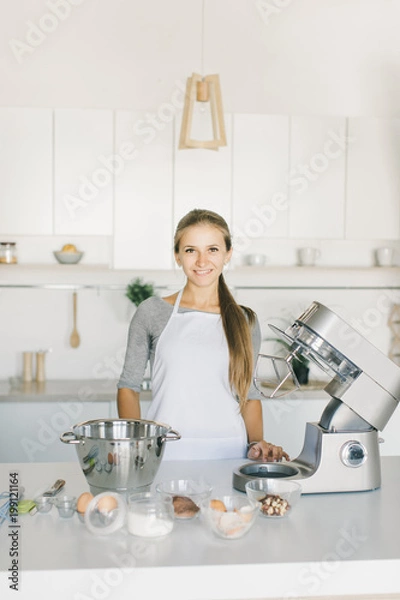 Obraz the girl is cooking in the kitchen