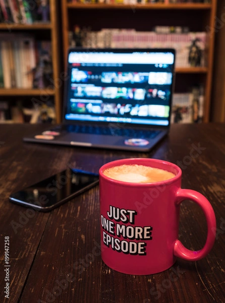 Fototapeta Watching series with a cup of tea on wood table with cellphone. Just one more episode. Millennial concept.