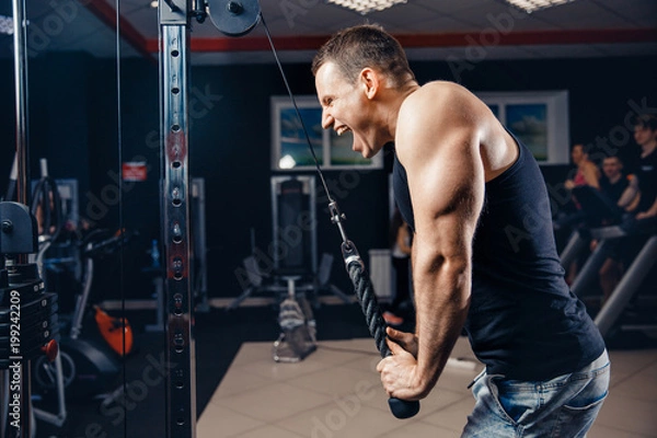 Fototapeta Workout man is doing triceps exercises with screaming, motivation. Concept strong man