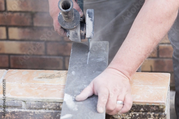 Fototapeta tiler cutting a tile with a grinder