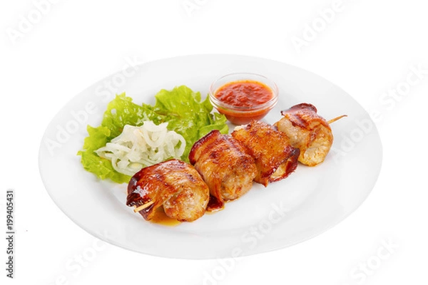 Fototapeta Shish kebab, beef, lamb, pork, chicken in bacon grilled meat, barbecue, without garnish on a plate, isolated on white background. Marinated onion, ketchup, tomato red sauce. Side view For the menu