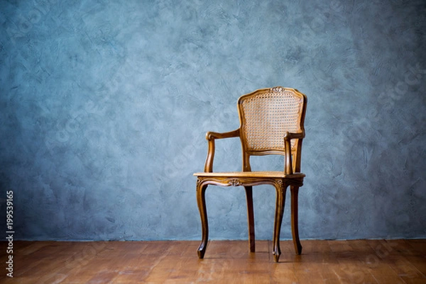 Obraz old chair on a gray wall background.