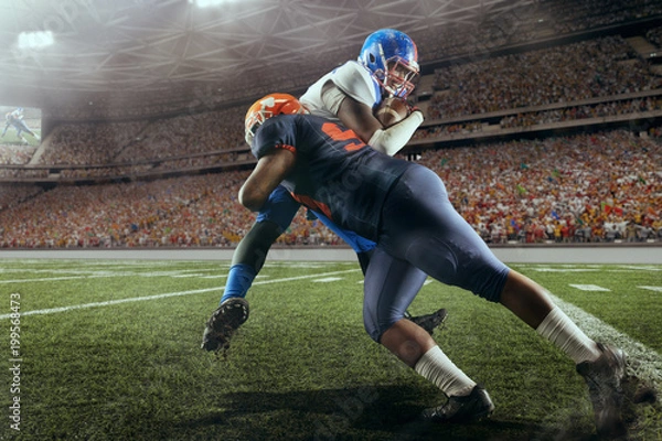 Obraz American football players preforms an action play in professional sport stadium