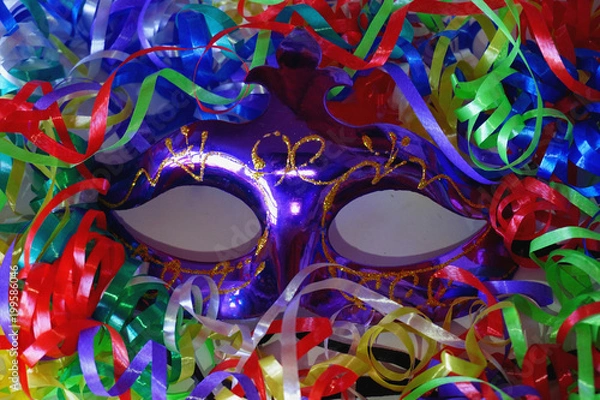Fototapeta Anonymous violet carnaval mack with spripes, ribbons, confetti, tinsel. 