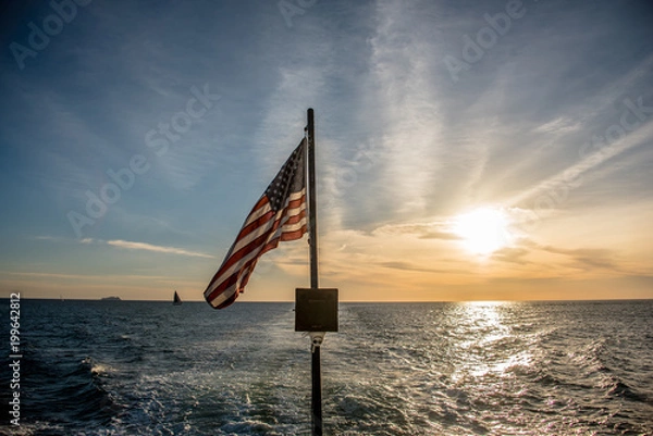 Obraz American flag flying from a sailboat at sea