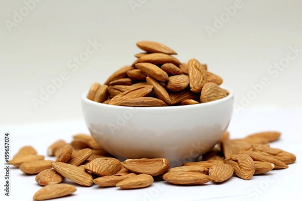 Fototapeta Almond mamra giri isolated. Group of almond nuts isolated on white background. Full depth of field