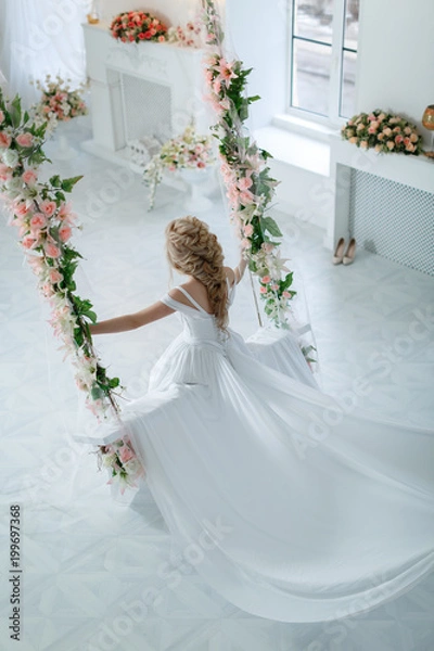 Fototapeta Девушка в свадебном платье на качелях