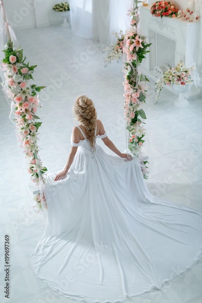 Fototapeta Девушка в свадебном платье на качелях