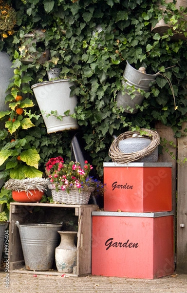 Fototapeta Garden wall with planters and decorative boxes