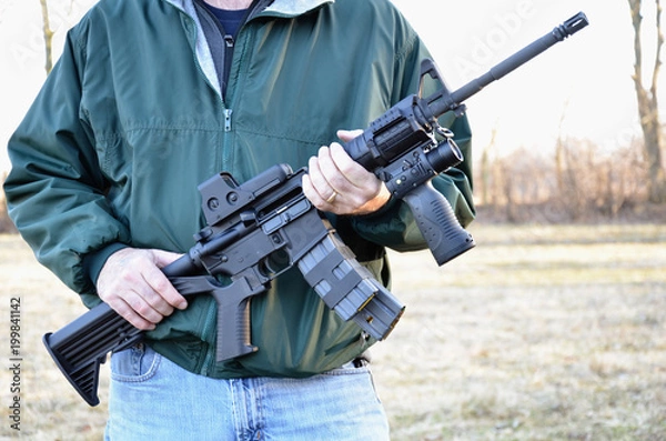 Fototapeta AR-15, M-4 style rifle being held.