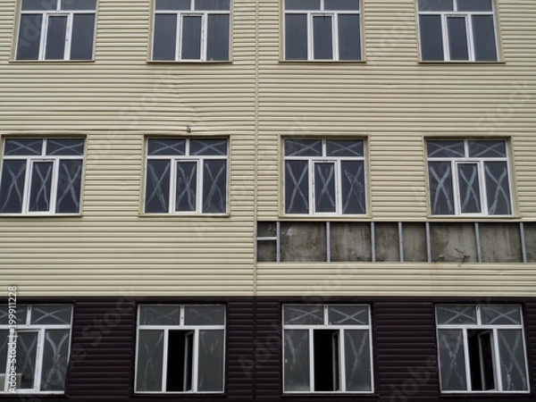 Fototapeta Wall of an abandoned building. Modern building. Grunge urban background. Unfinished building. WIndows