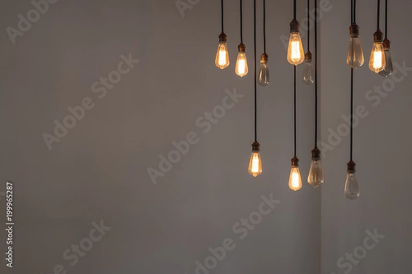 Fototapeta Idea concept with good and broken light bulbs hanging from ceiling