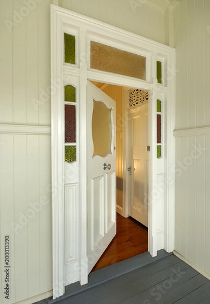 Obraz Door to old colonial style wooden home, slightly open with warm interior light in Queensland Australia.