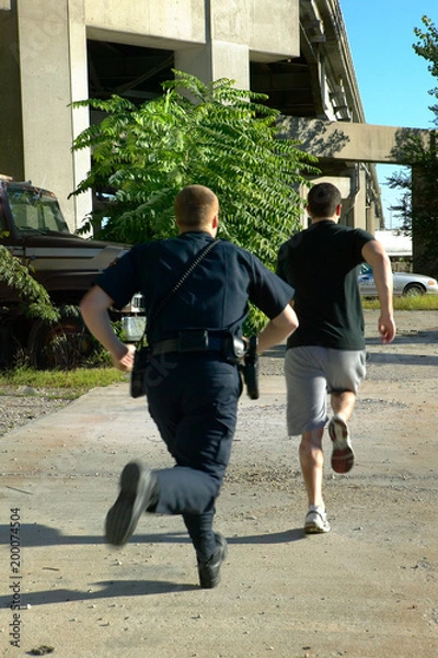 Obraz Policeman chasing after suspect man