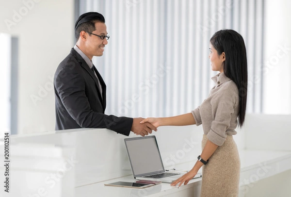 Fototapeta Happy Businessman in Hotel check in at reception or front office being given key card. Classy welcome Concept.