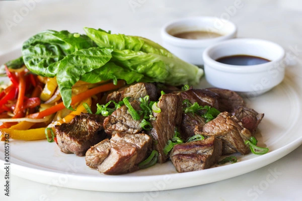 Fototapeta Grilled sliced beef steak with lettuce and chopped pepper - Stok Photo