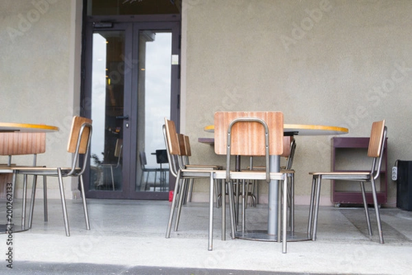 Fototapeta интерьер в кафе, деревянные стулья на фоне серой стены.