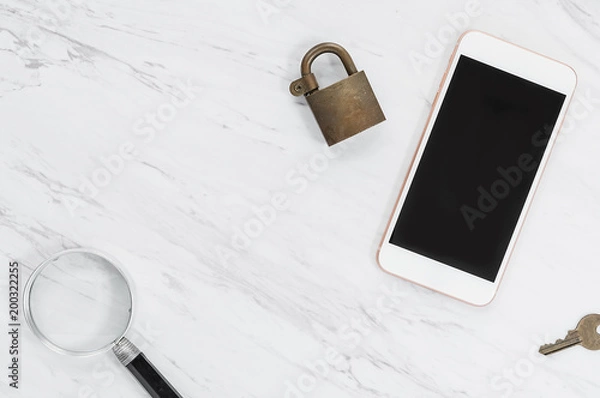 Fototapeta Mobile phone with padlock on top, key and magnifying glass nearby