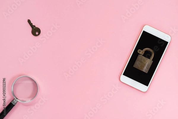 Fototapeta Mobile phone with padlock on top, key and magnifying glass nearby