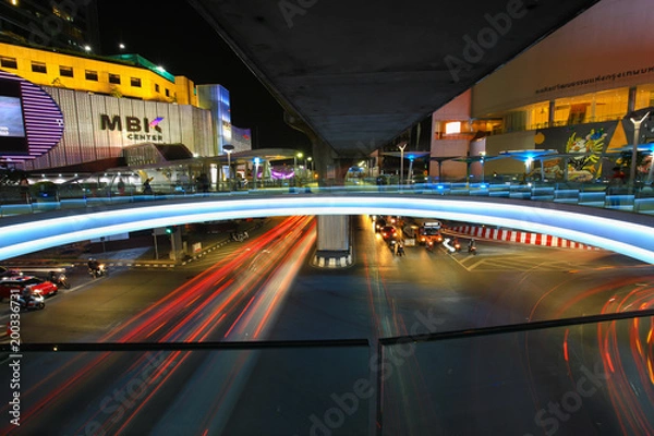 Obraz Bangkok,Thailand - 31 October 2017 : Night light with long speed shutter of traffic at MBK, BTS Siam interchange in front of Siam Discovery and Art Museum junction on Halloween night