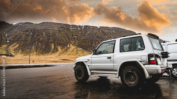 Obraz offroad car between snowy mountains