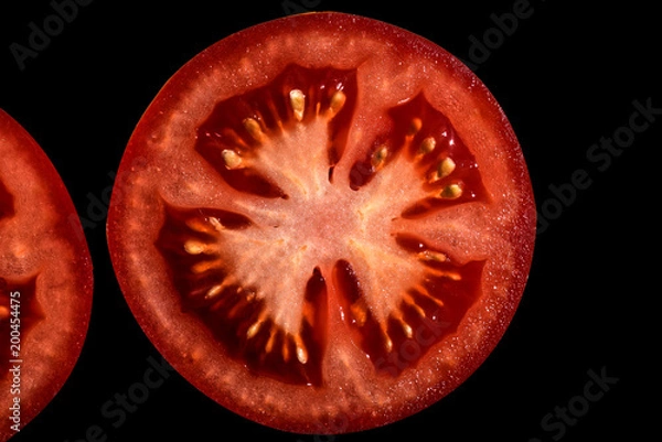 Obraz Sliced tomato isolated on black background. Texture tomato pulp. Red flesh and yellow seeds.