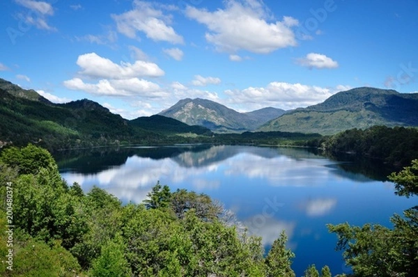 Obraz Horizontal photo of lake Machonico in Argentina with water reflection on the foreground and mountains and clouds in the background